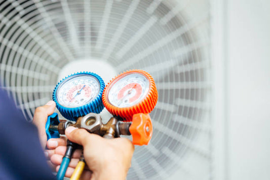 HVAC technician installing a new air conditioner condenser compatible with R32 or R454B refrigerants.