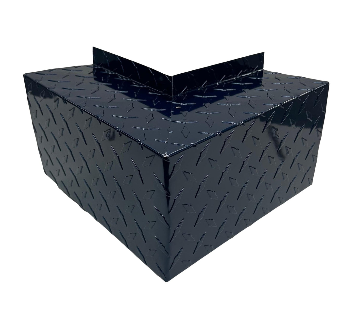 A black metal box with a triangular pattern is shaped like a right-angle corner piece. Its reflective surface and angular design give it an industrial appearance. The box, featuring Residential Series - Line Set Cover Outside Corner Elbows - Premium Quality by Perma Cover, appears to be designed for fitting into a corner for simple and easy installation.