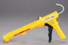 A yellow Perma Cover Dripless ETS1100 Caulking Gun - 10oz Composite Body, Full Time Dripless Function with a black handle and trigger, designed to hold and dispense caulk or sealant. The metal rod and hook at the back assist in advancing the caulk tube. Featuring a dripless design with a 10:1 thrust ratio, this lightweight composite body tool is placed against a neutral gray background.