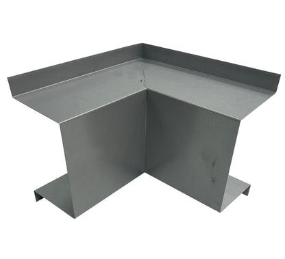 A photograph of a Perma Cover Residential Series - Line Set Cover Inside Corner Elbows - Premium Quality with a 90-degree angle, designed for construction or structural purposes. The piece features flanges on each side for attachment to other materials, commonly used in HVAC installations. The metal has a smooth, metallic finish.
