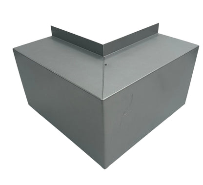 A metallic, angular box with a prominent V-shaped top edge and smooth surfaces. The box's design suggests it could be a Perma Cover Residential Series - Line Set Cover Outside Corner Elbows - Premium Quality for industrial or HVAC applications. The metal appears to be galvanized steel, indicating potential use for outdoor or exposed installations.