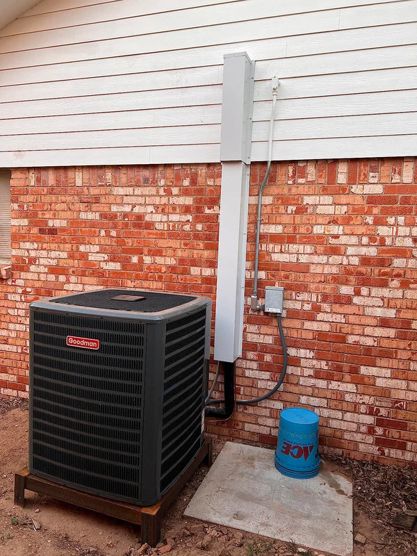 Metal HVAC line set covers installed to hide AC lines on a residential exterior wall