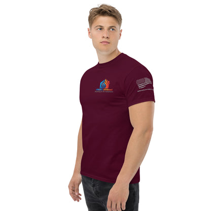 A young man wearing a MRCOOL DIY Direct custom-designed burgundy t-shirt with a logo on the left chest and an American flag on the right sleeve, standing against a white background.